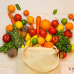 owoce i warzywa wysypujące się z wielorazowej torby za zakupy